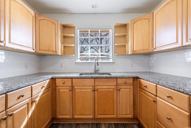 kitchen with tasteful backsplash, light stone counters, open shelves, and a sink