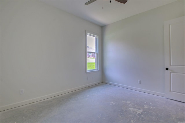 unfurnished room with ceiling fan, concrete floors, and baseboards