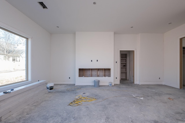 unfurnished living room featuring visible vents and unfinished concrete flooring