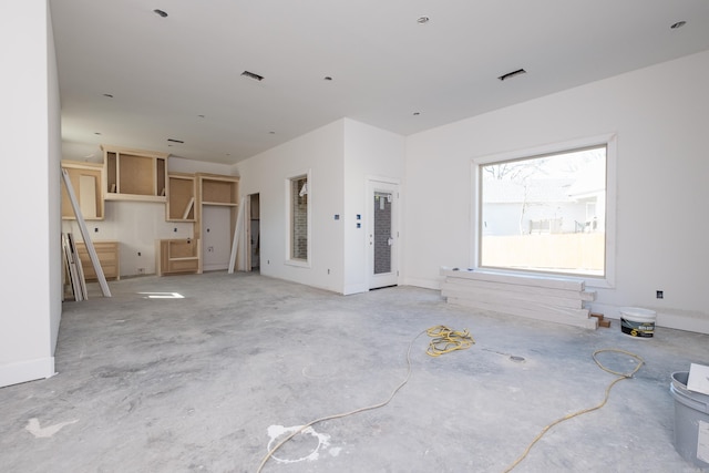 unfurnished living room featuring visible vents and unfinished concrete floors