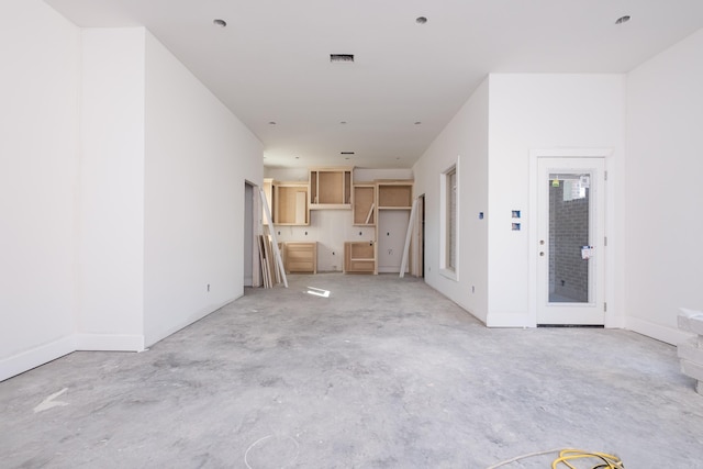 unfurnished living room featuring concrete floors and visible vents