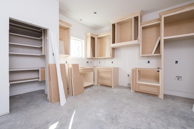 kitchen with concrete floors and light brown cabinetry