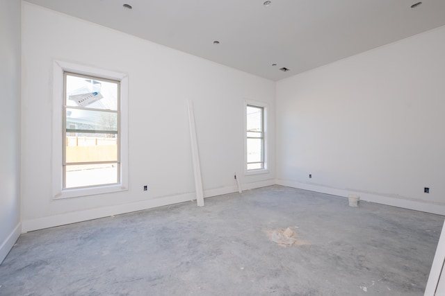 empty room with baseboards, visible vents, and unfinished concrete floors