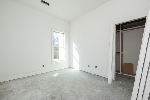 unfurnished bedroom with concrete floors, visible vents, and a closet