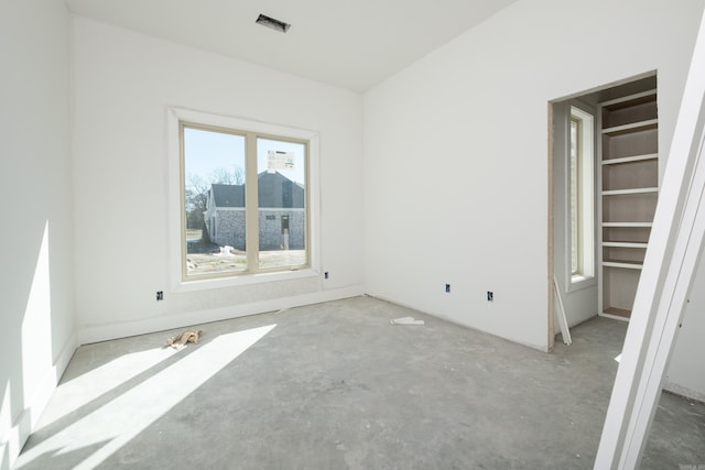 unfurnished room with unfinished concrete flooring and visible vents