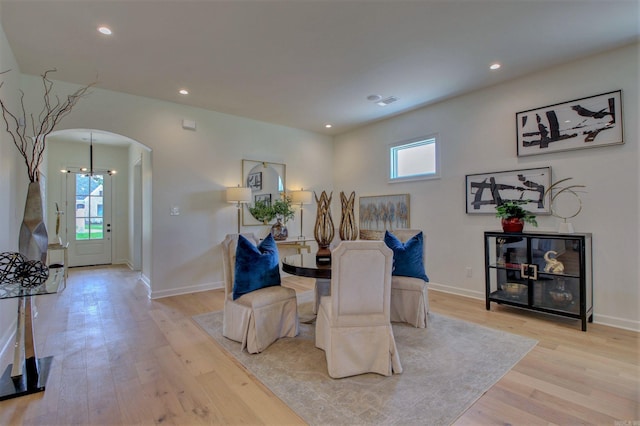 dining space featuring light wood-type flooring, arched walkways, a healthy amount of sunlight, and recessed lighting