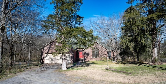 view of yard with driveway, a garage, and fence