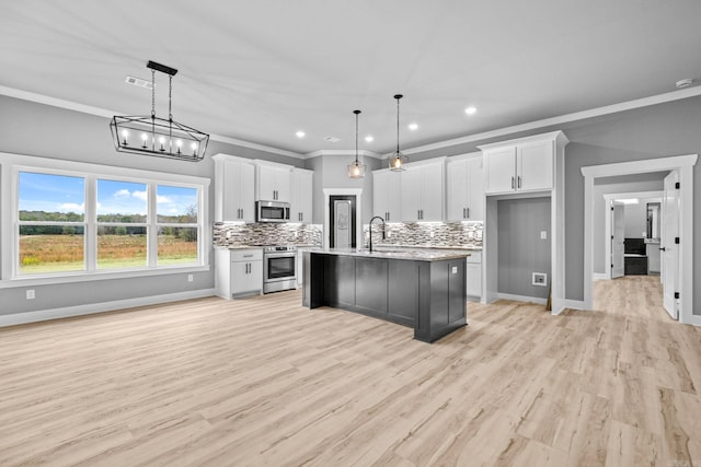 kitchen featuring appliances with stainless steel finishes, white cabinets, and decorative backsplash