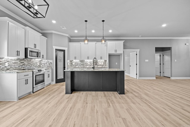 kitchen with stainless steel appliances, a sink, visible vents, and white cabinets