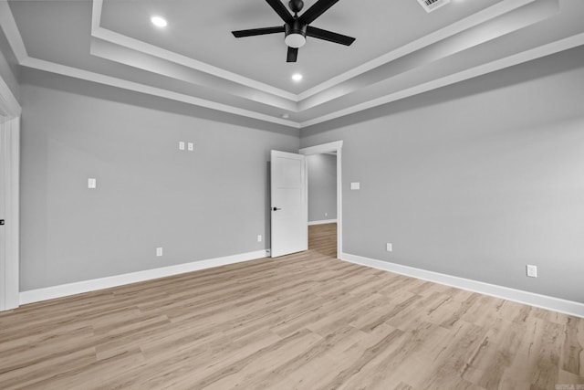 empty room featuring baseboards, light wood-style flooring, ceiling fan, a tray ceiling, and recessed lighting