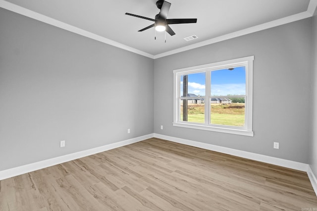 empty room featuring baseboards, visible vents, wood finished floors, and ornamental molding