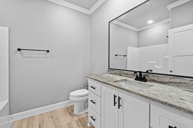 full bathroom featuring toilet, wood finished floors, vanity, baseboards, and ornamental molding