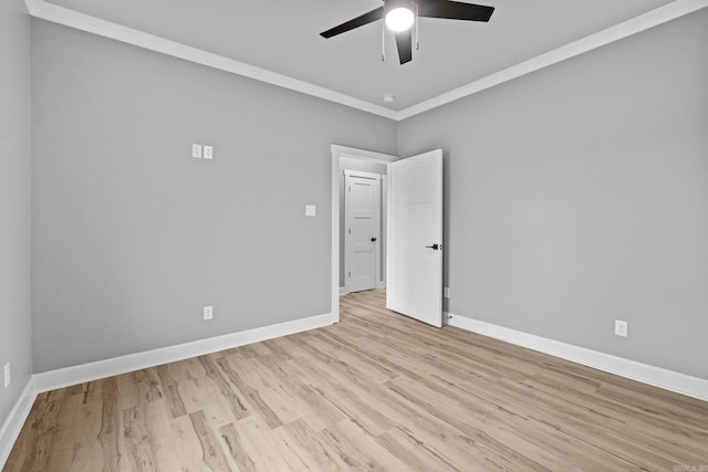 unfurnished room with ornamental molding, light wood finished floors, baseboards, and a ceiling fan