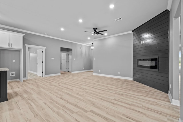 unfurnished living room with light wood finished floors, baseboards, ceiling fan, crown molding, and a fireplace