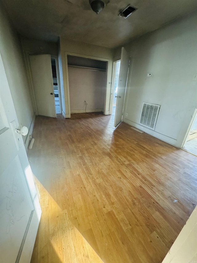 spare room featuring light wood-style flooring and visible vents