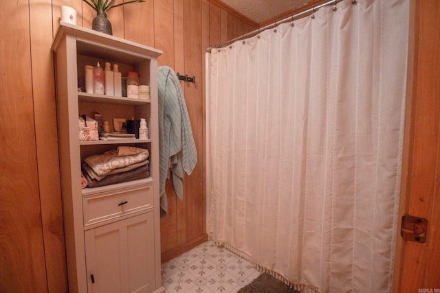 full bathroom featuring curtained shower, wooden walls, and tile patterned floors