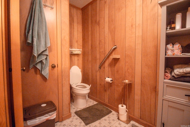 bathroom featuring wood walls, toilet, and tile patterned floors