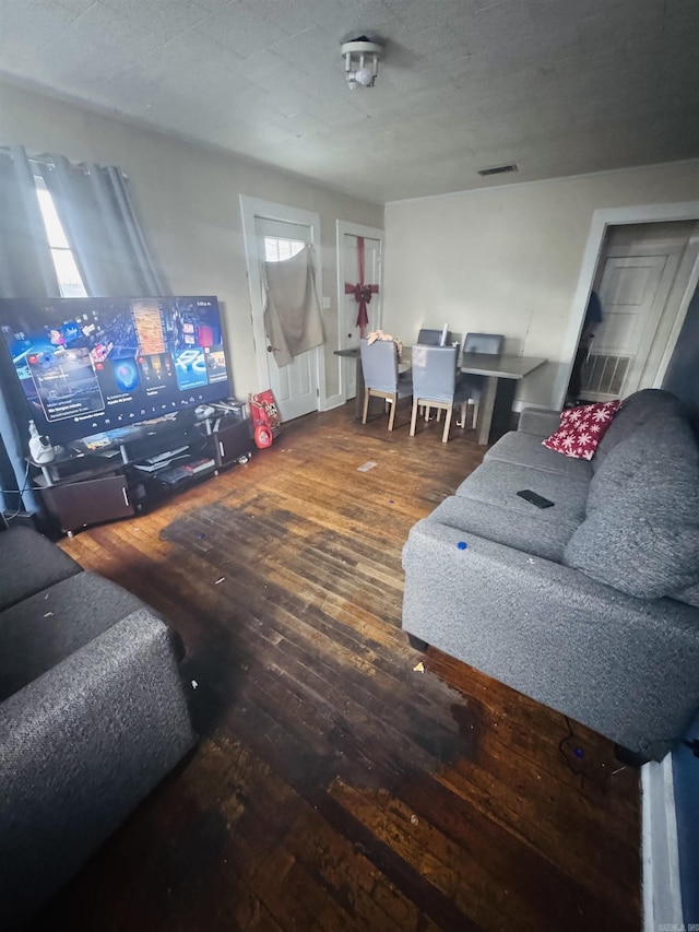 living room with visible vents, a textured ceiling, and wood finished floors