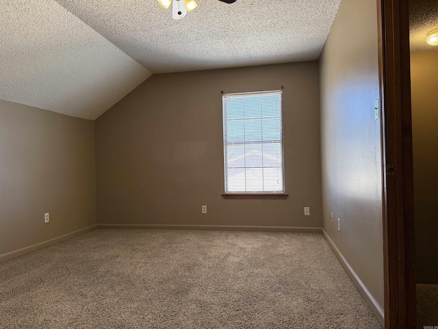 additional living space featuring lofted ceiling, carpet flooring, ceiling fan, a textured ceiling, and baseboards