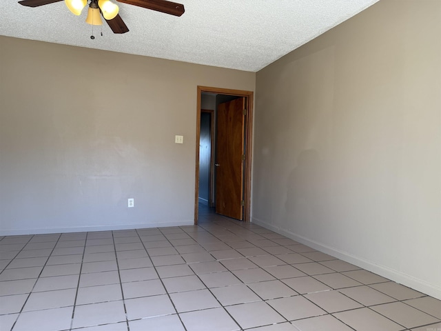 unfurnished room featuring light tile patterned floors, ceiling fan, baseboards, and a textured ceiling