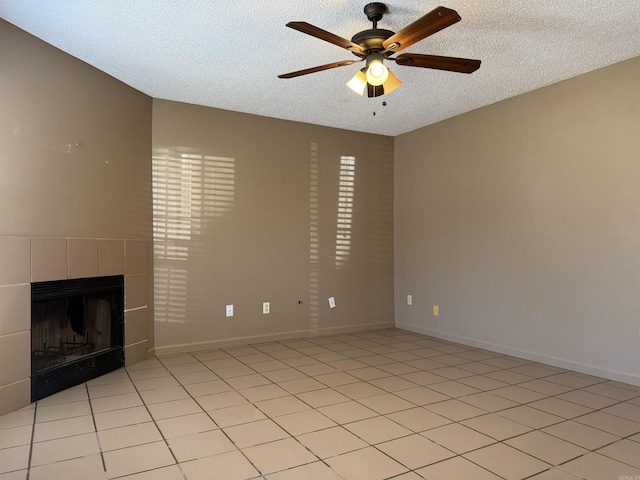 unfurnished living room featuring a textured ceiling, light tile patterned floors, a fireplace, a ceiling fan, and baseboards