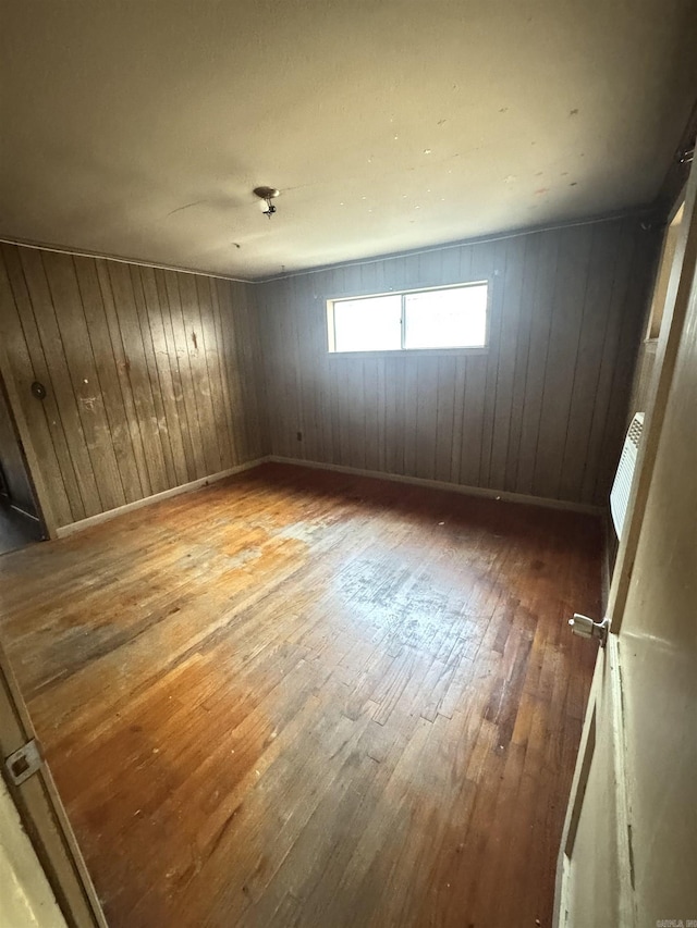 unfurnished room with wood-type flooring and baseboards