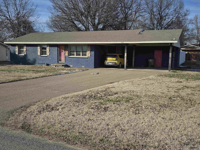 ranch-style home featuring brick siding, a shingled roof, crawl space, a carport, and driveway