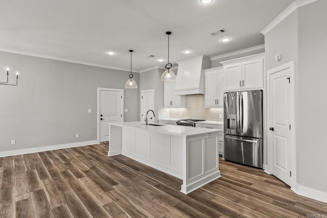 kitchen with premium range hood, a sink, visible vents, appliances with stainless steel finishes, and crown molding