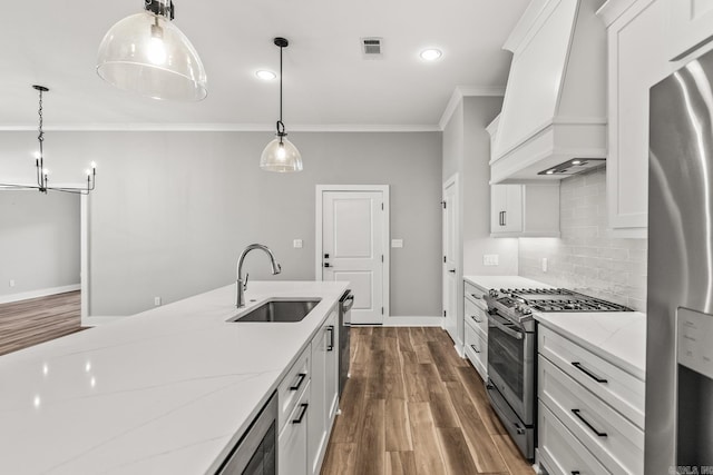 kitchen featuring visible vents, appliances with stainless steel finishes, ornamental molding, premium range hood, and a sink