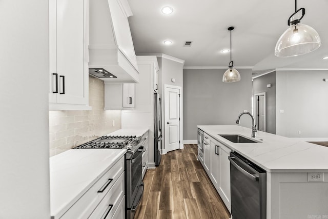 kitchen featuring stainless steel appliances, a sink, visible vents, custom exhaust hood, and an island with sink