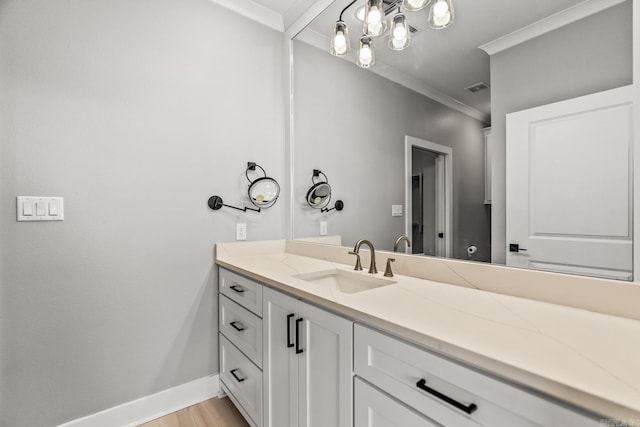 bathroom with visible vents, ornamental molding, vanity, wood finished floors, and baseboards