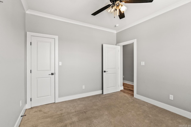 unfurnished bedroom with carpet floors, baseboards, and crown molding