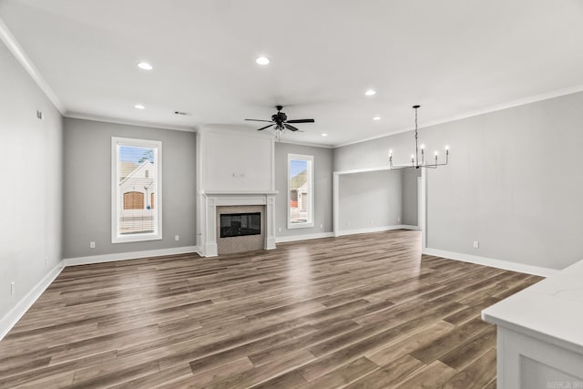 unfurnished living room featuring a glass covered fireplace, dark wood finished floors, baseboards, and recessed lighting