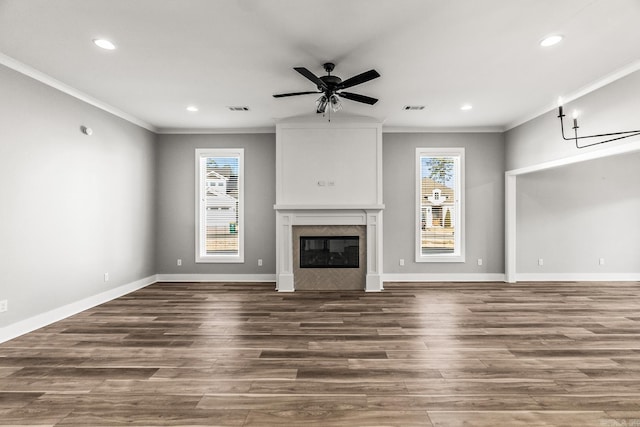 unfurnished living room with a ceiling fan, a glass covered fireplace, visible vents, and wood finished floors