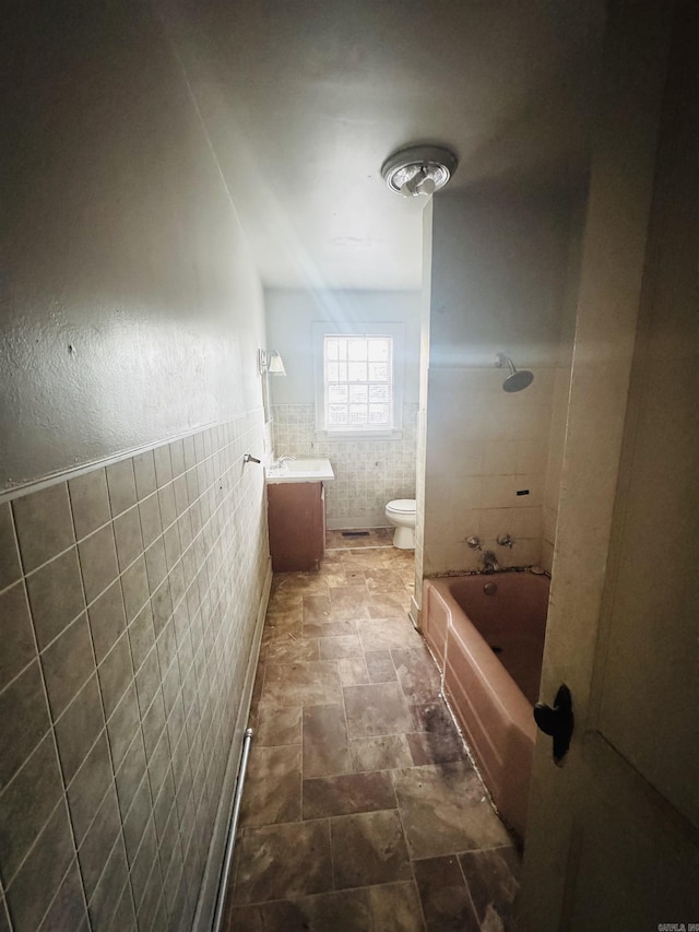 913 W Calhoun, Magnolia, AR 71753 - bathroom with toilet, stone finish floor, tub / shower combination, vanity, and tile walls
