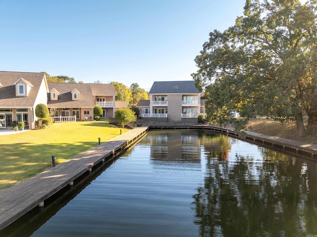 dock area with a lawn and a water view