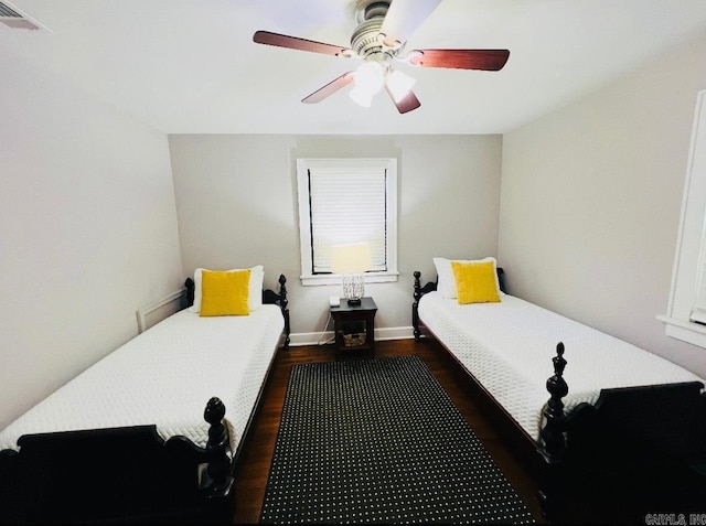 bedroom with dark wood-style floors, visible vents, and a ceiling fan