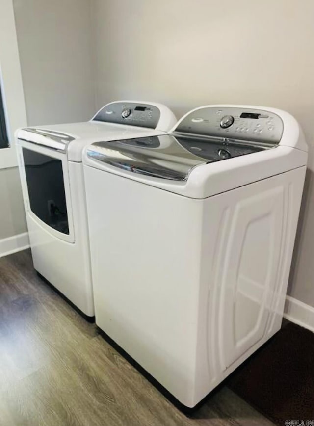 laundry room with wood finished floors, laundry area, baseboards, and separate washer and dryer