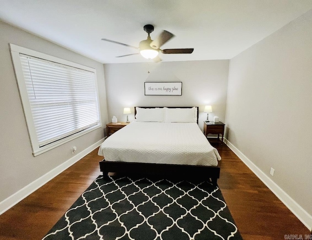 bedroom with ceiling fan, wood finished floors, and baseboards