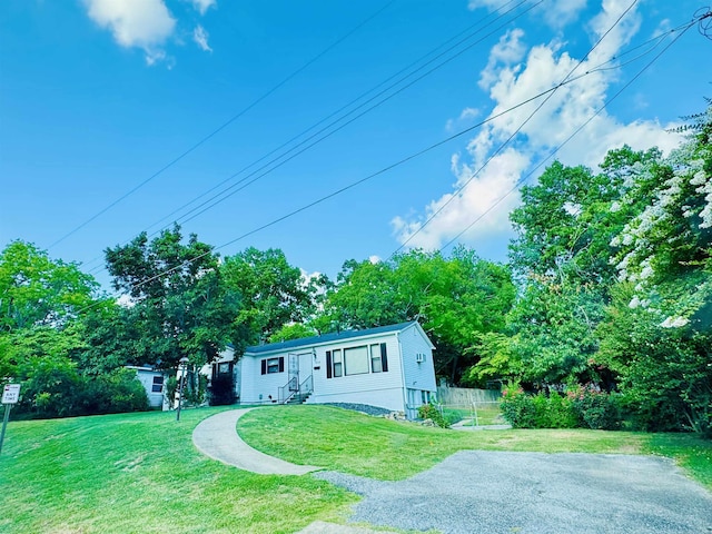 view of front of house with entry steps, fence, and a front yard