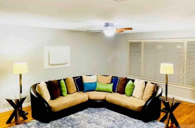 living area featuring ceiling fan, baseboards, and wood finished floors