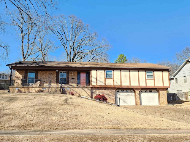 view of front of home with a garage, fence, and brick siding