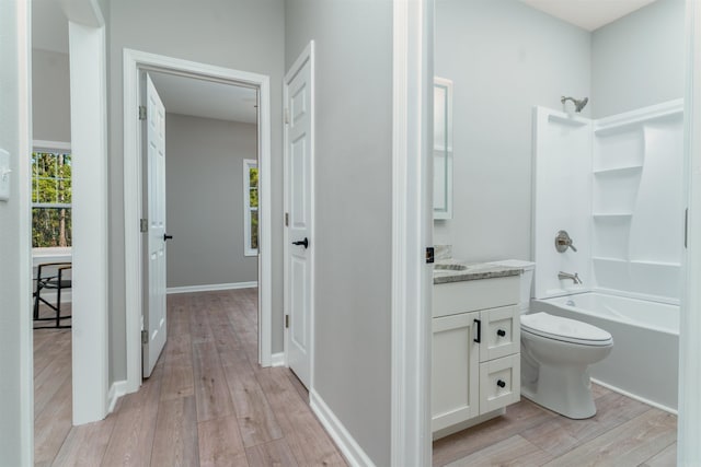 bathroom with shower / bath combination, vanity, toilet, and wood finished floors