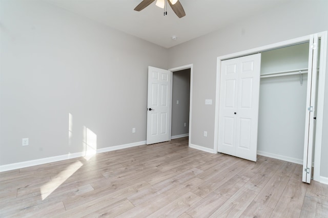 unfurnished bedroom with light wood-style flooring, baseboards, ceiling fan, and a closet