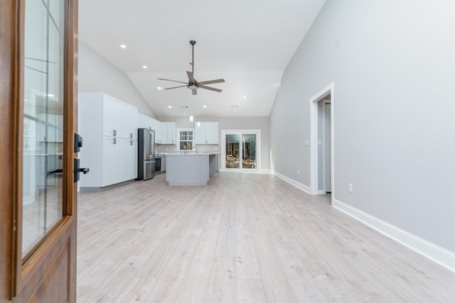 unfurnished living room featuring light wood finished floors, recessed lighting, a ceiling fan, high vaulted ceiling, and baseboards