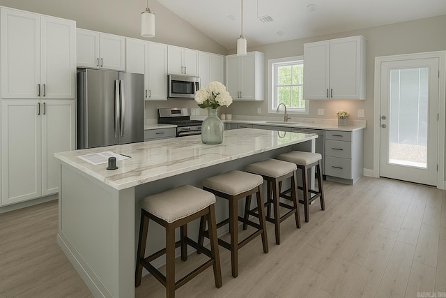 2 Tolosa Way, Hot Springs Village, AR 71909 - kitchen featuring stainless steel appliances, light wood-style floors, a center island, a kitchen bar, and a sink
