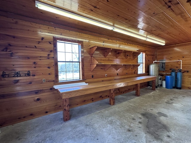 interior space featuring concrete floors, wood ceiling, and wood walls