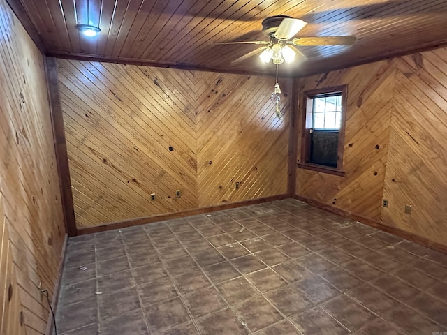 empty room with wood walls, wooden ceiling, and a ceiling fan