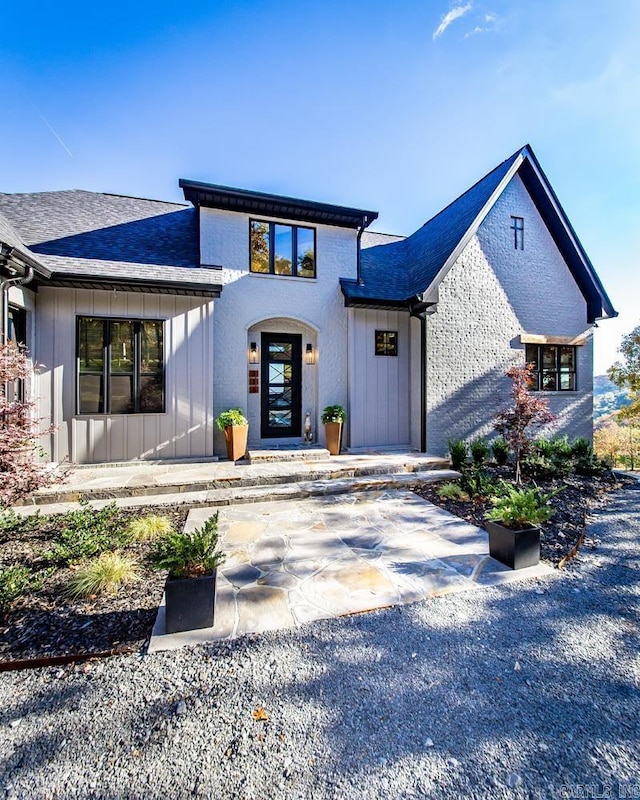 view of front of property featuring board and batten siding and roof with shingles