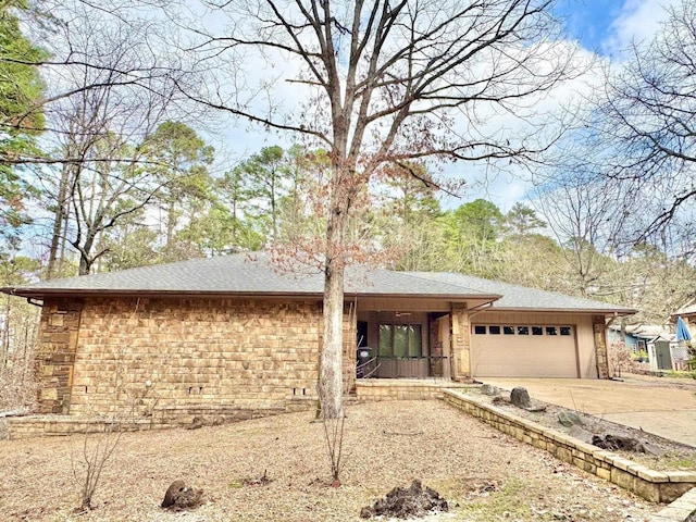 view of front of home with an attached garage, concrete driveway, and roof with shingles